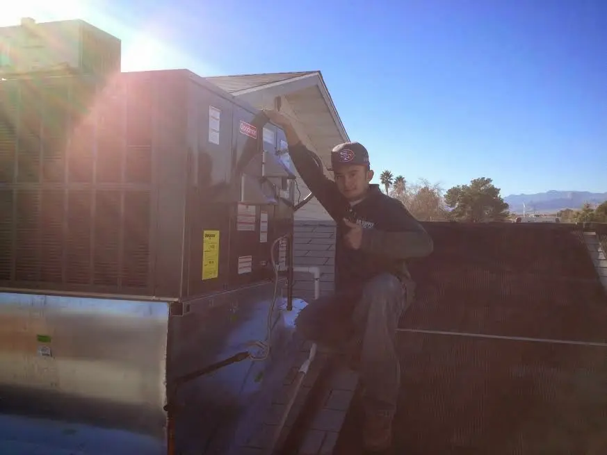 HVAC technician performing Air Duct Repair on a rooftop unit in Suncrest